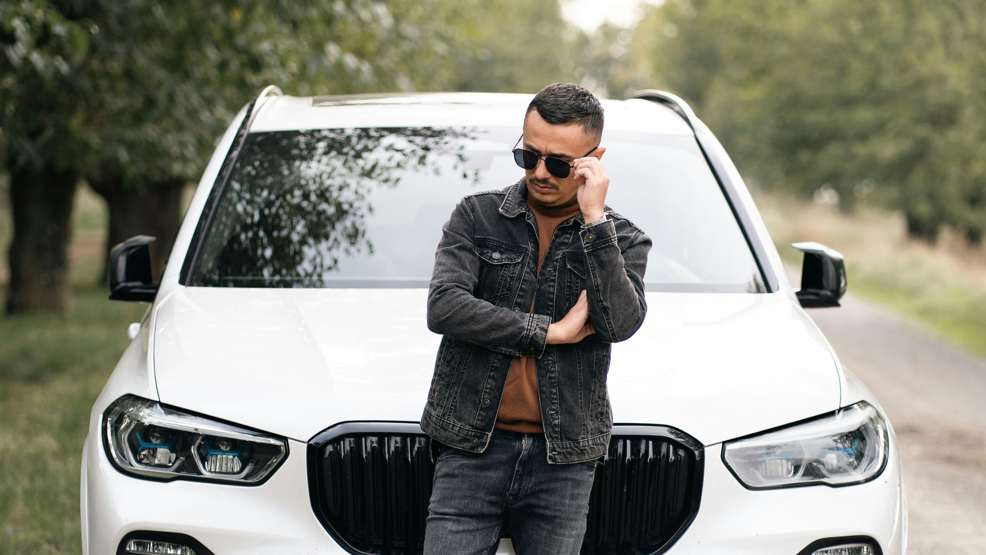 A man standing in front of a white car