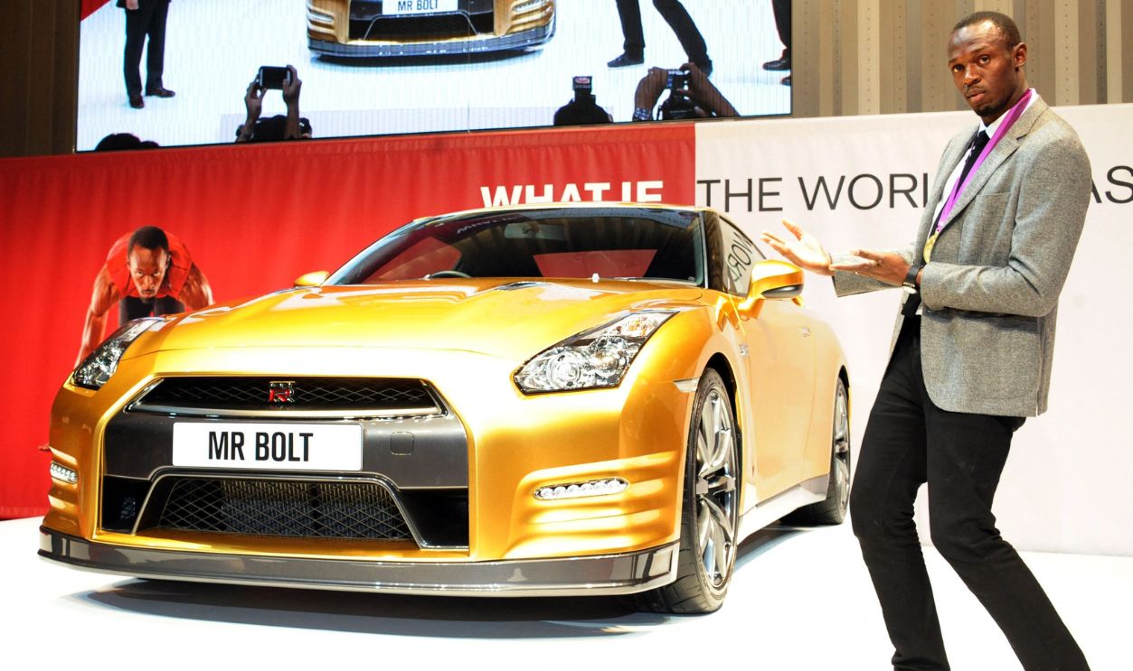 Olympic gold medallist Usain Bolt of Jamaica poses for a photo in front of Japanese auto giant Nissan's gold coloured sports car GT-R at Nissan's headquarters in Yokohama on October 11, 2012. The special coloured GT-R will be auctioned at eBay auction site to benefit the Usain Bolt Foundation supporting youth
