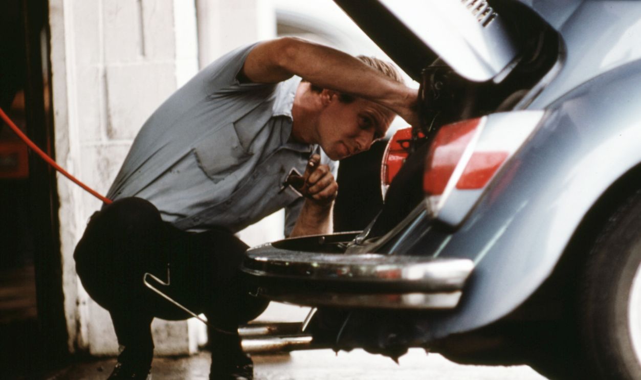 September 1975 - Service Station Mechanic Adjusts the Engine for a Young Woman Whose Vehicle Had Failed the Emissions Test at an Auto Emission Inspection Station in Downtown Cincinnati, Ohio...09/1975 Service Station Mechanic Adjusts the Engine for a Young Woman Whose Vehicle Had Failed the Emissions Test at an Auto Emission Inspection Station in Downtown Cincinnati, Ohio...09/1975.