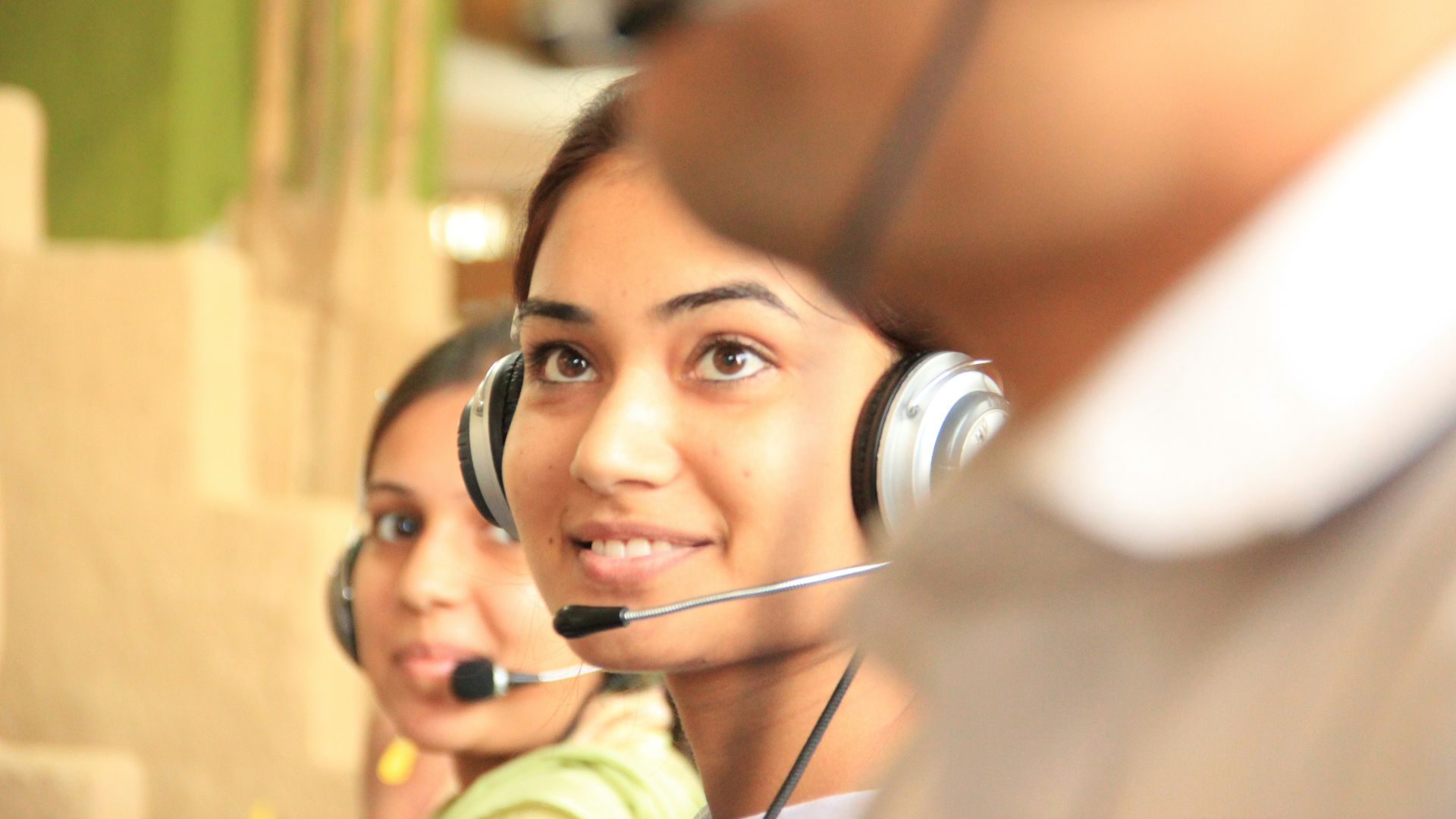 woman in black headphones holding black and silver headphones