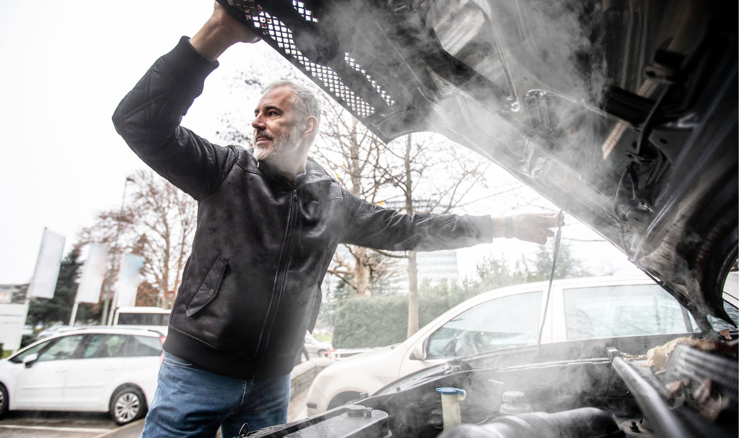 Steam Coming Out of Car Engine While Mature Man is Opening the Hood