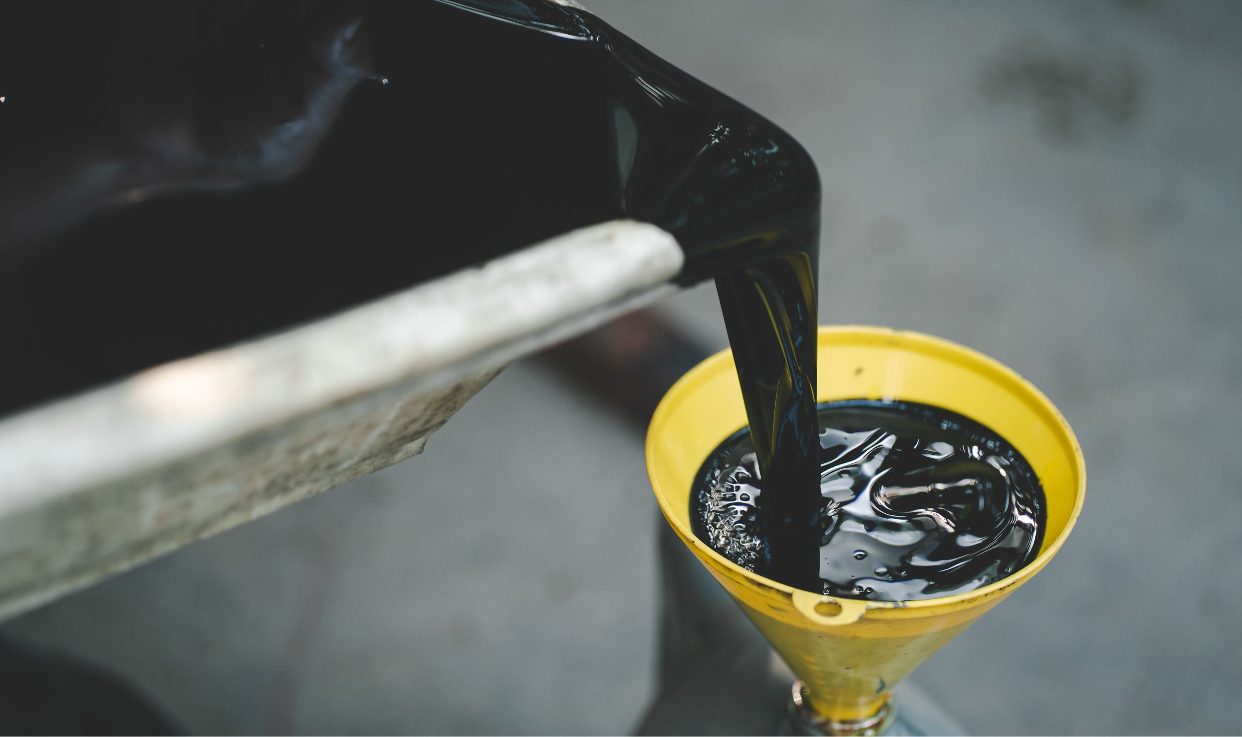 Old engine oil. Pouring old black oil of car engine from oil pan into bottle on top view lubrication used for recycle.