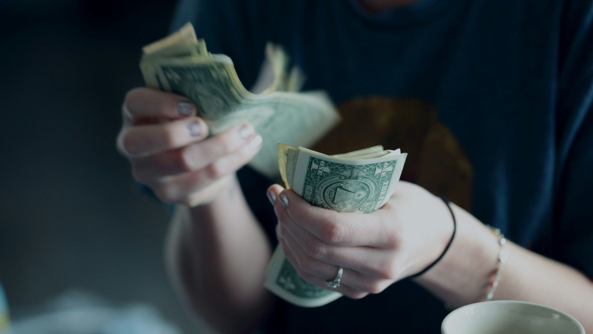 focus photography of person counting dollar banknotes