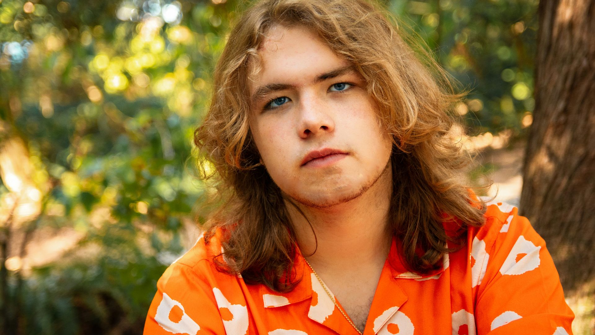 girl in orange and white floral collared shirt