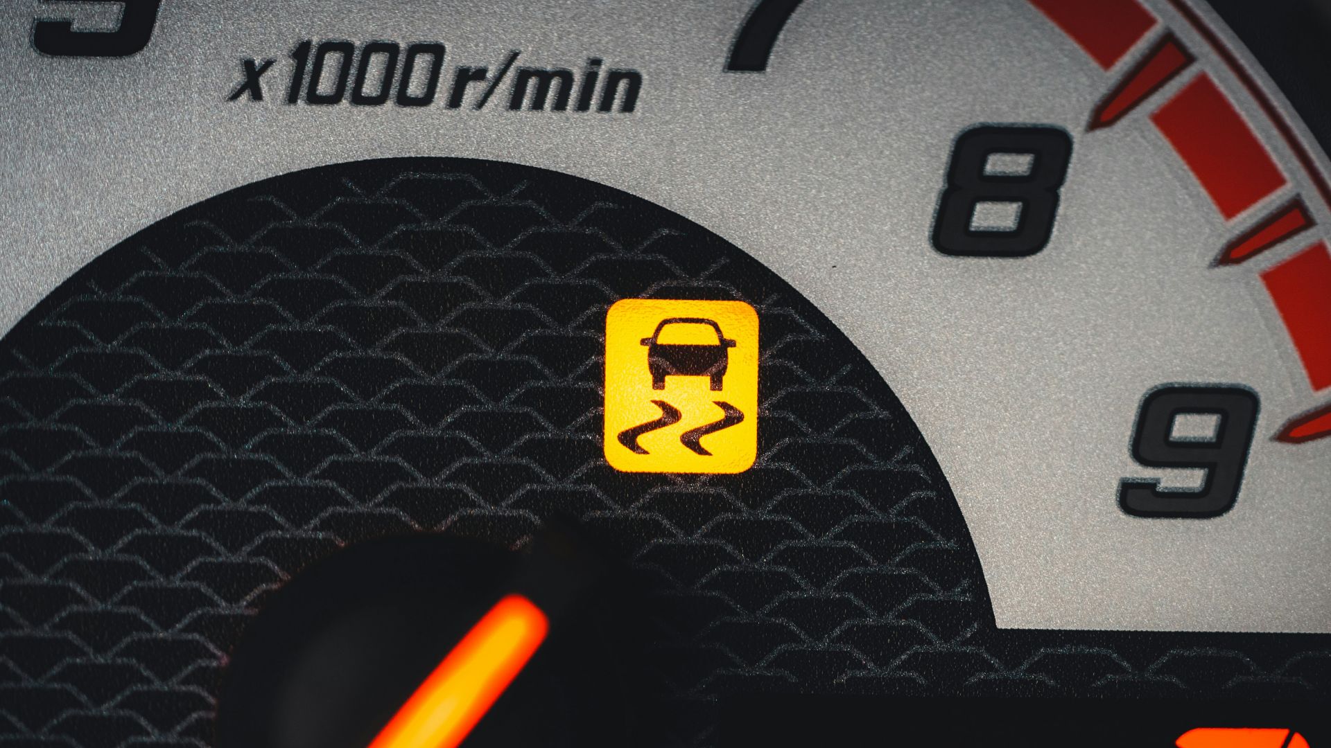 a close up of a speedometer with a yellow light