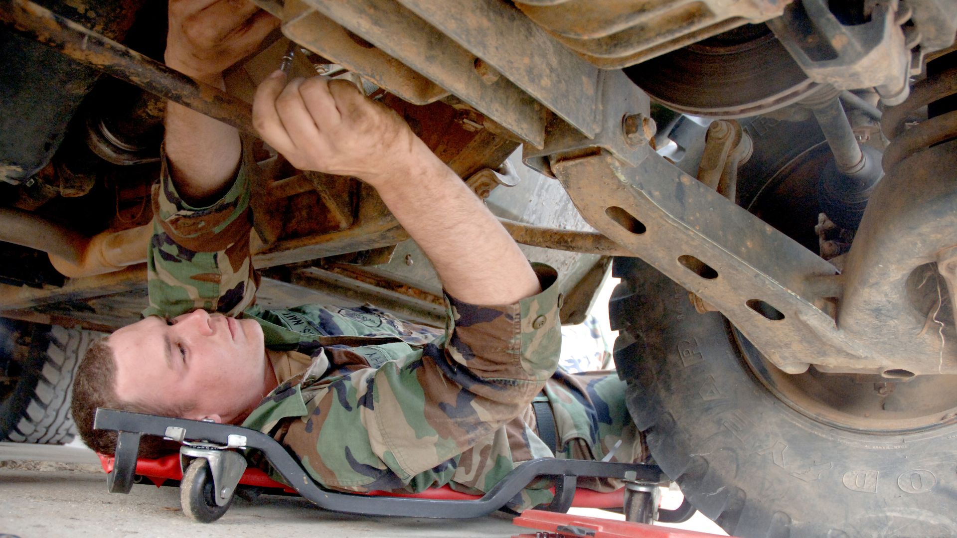 File:US Navy 060309-N-0553R-001 Construction Mechanic Sean Murphy, assigned to Naval Mobile Construction Battalion One (NMCB-1) reassembles a driveshaft on a High Mobility Multipurpose Wheeled Vehicle (HMMWV).jpg