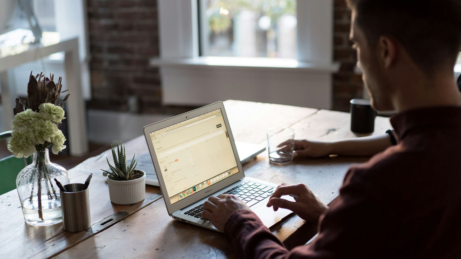 man operating laptop on top of table