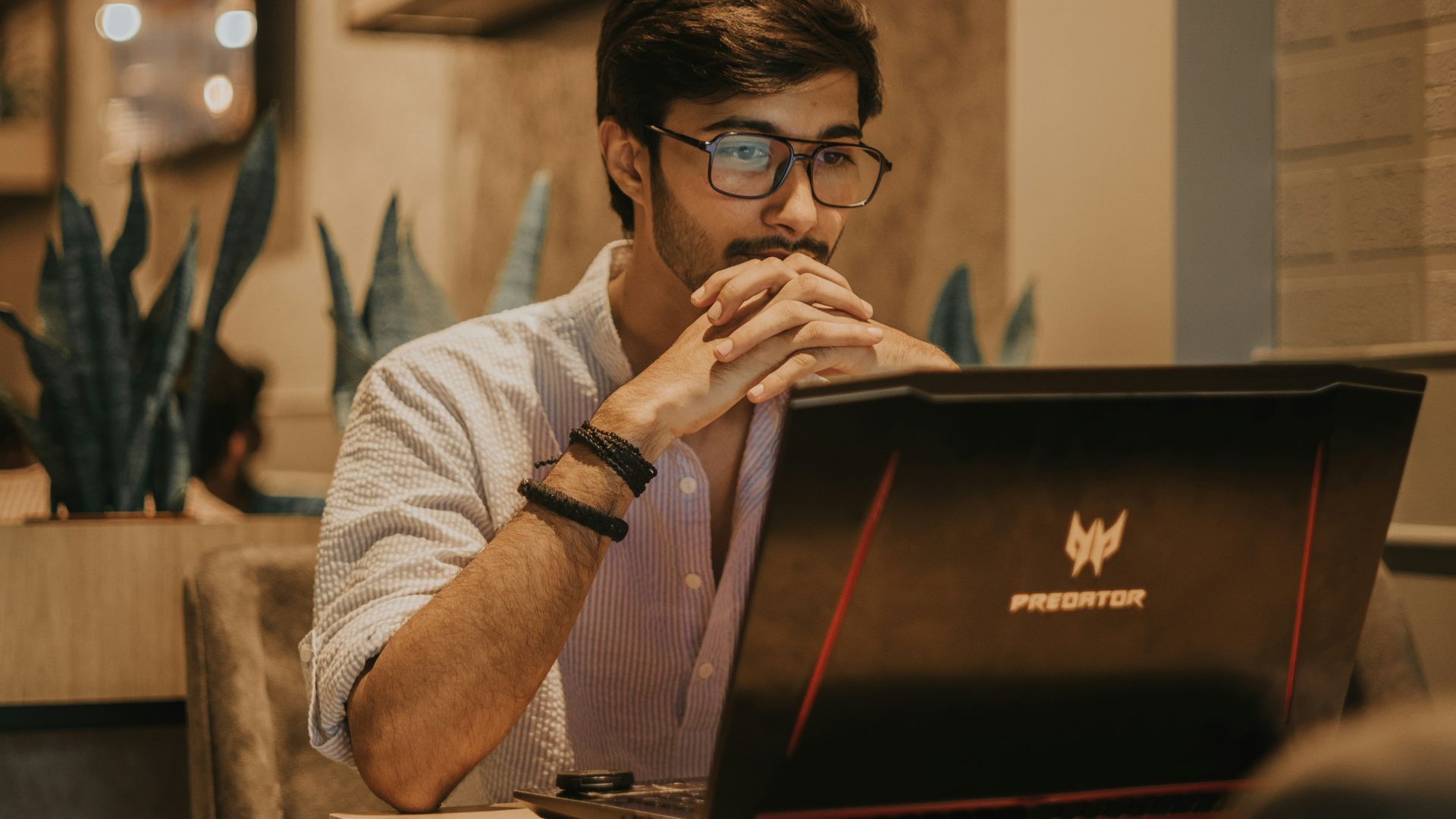 a man sitting at a table using a laptop computer