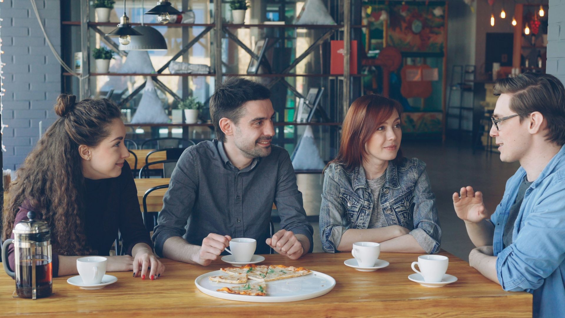 Friends chat and enjoy coffee at a cafe.