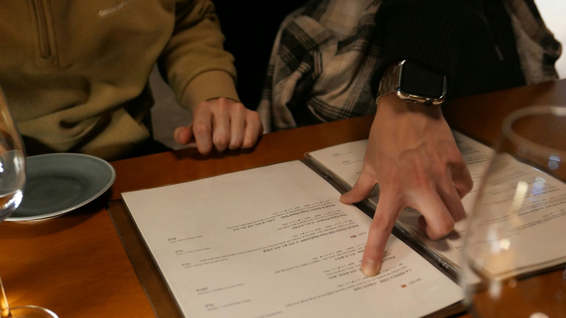 two people sitting at a table with a menu in front of them