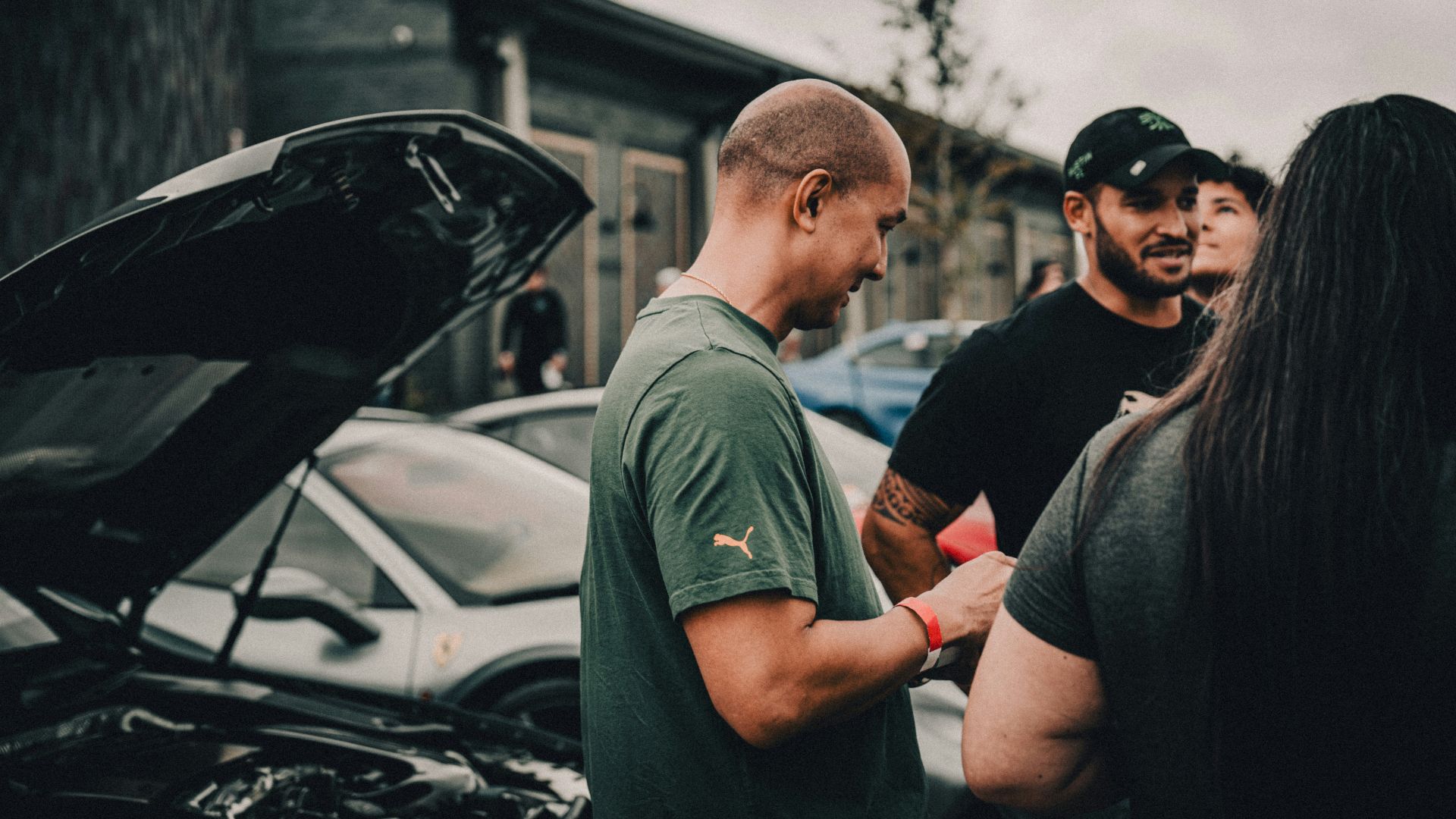 A group of people standing around a parked car