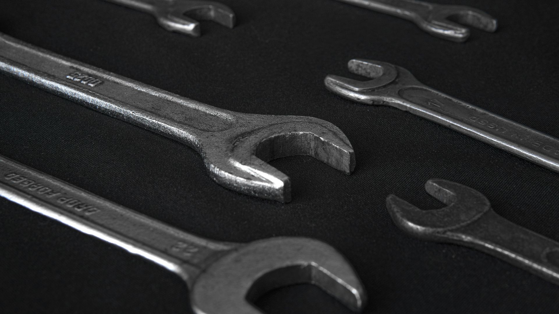 stainless steel wrench on black surface