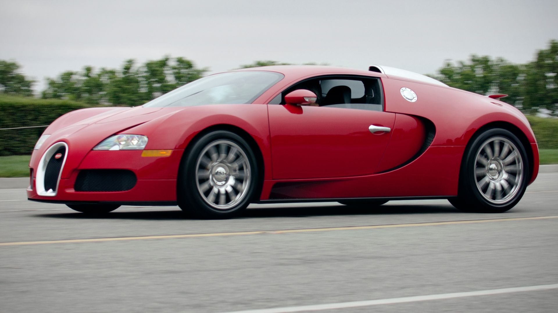 File:Red Bugatti Veyron on the road (7559997596).jpg