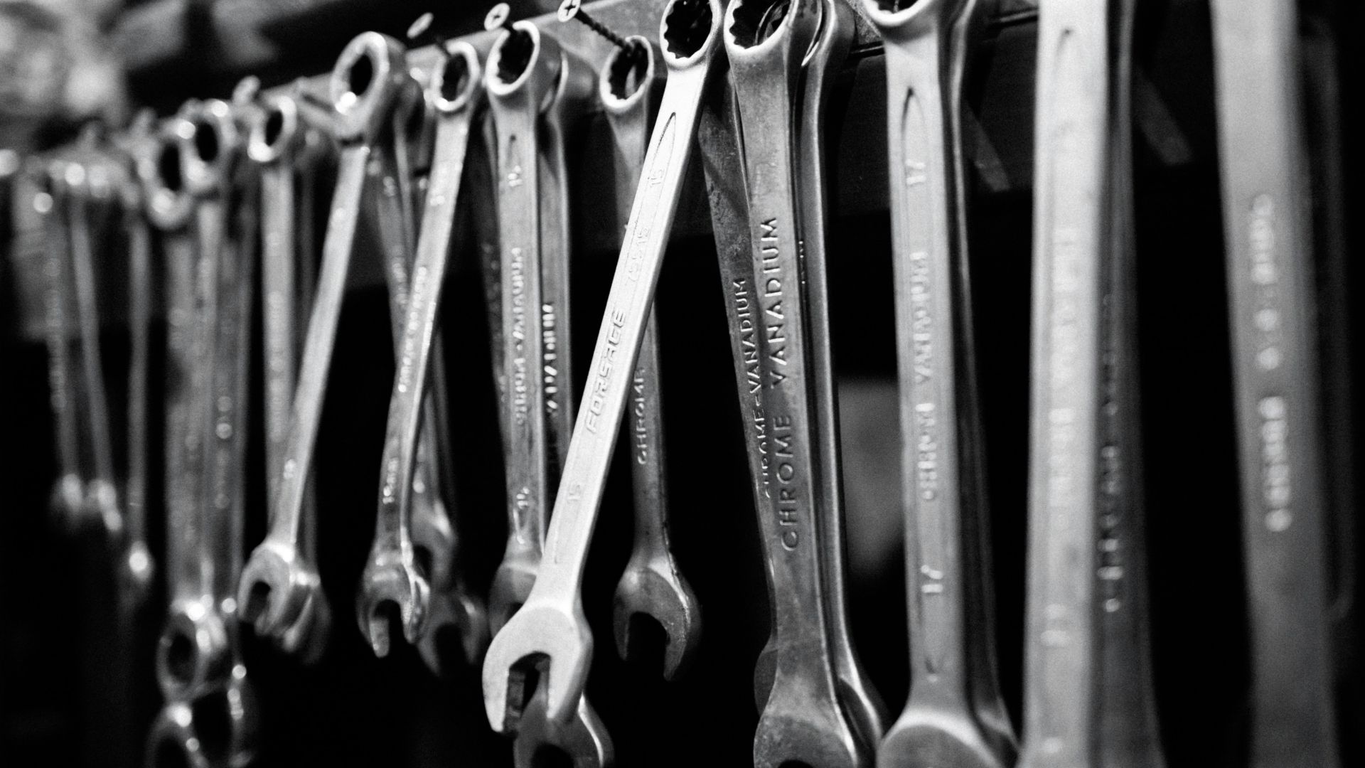 a bunch of wrenches are hanging on a rack