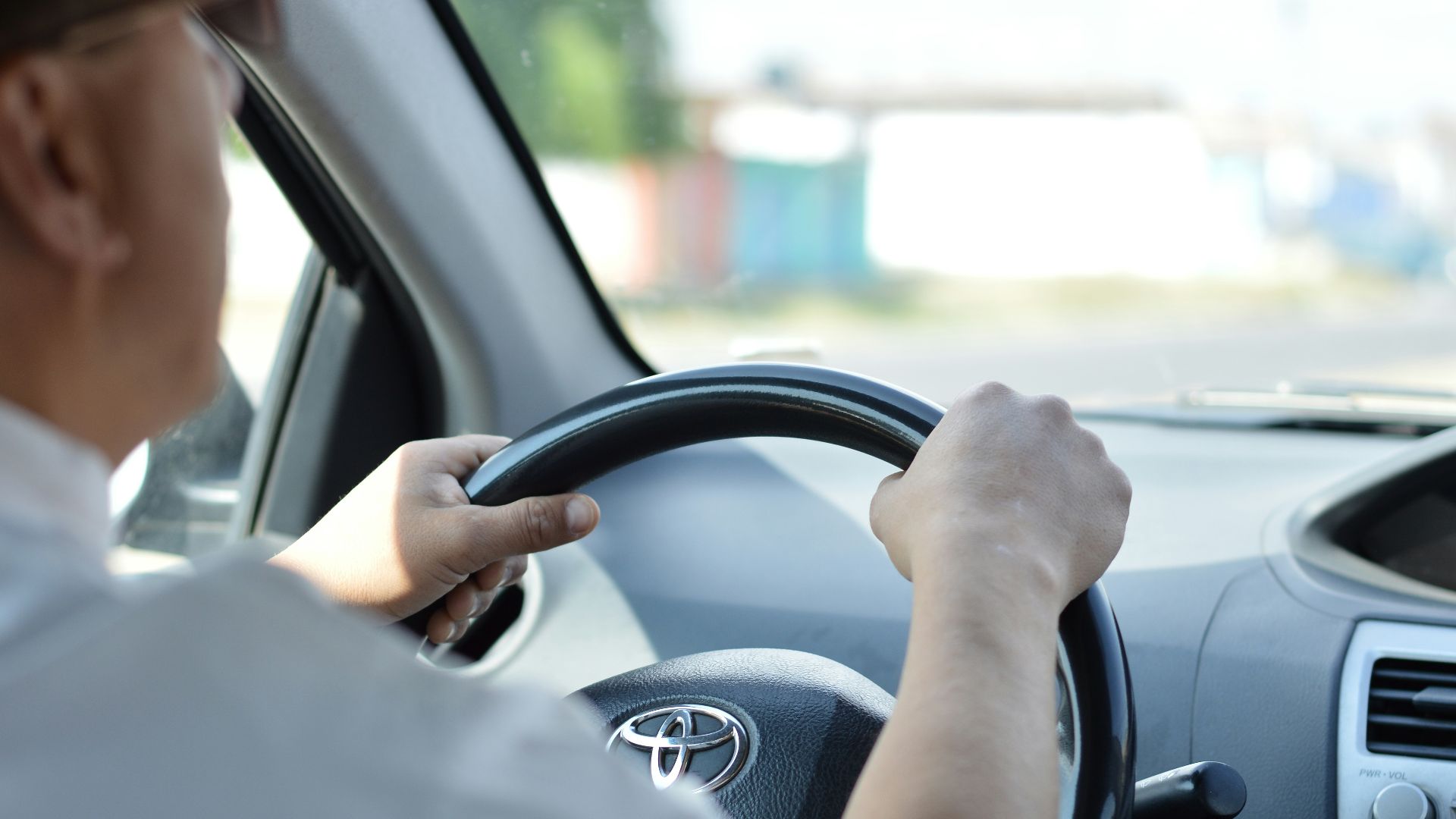 person in white long sleeve shirt driving car