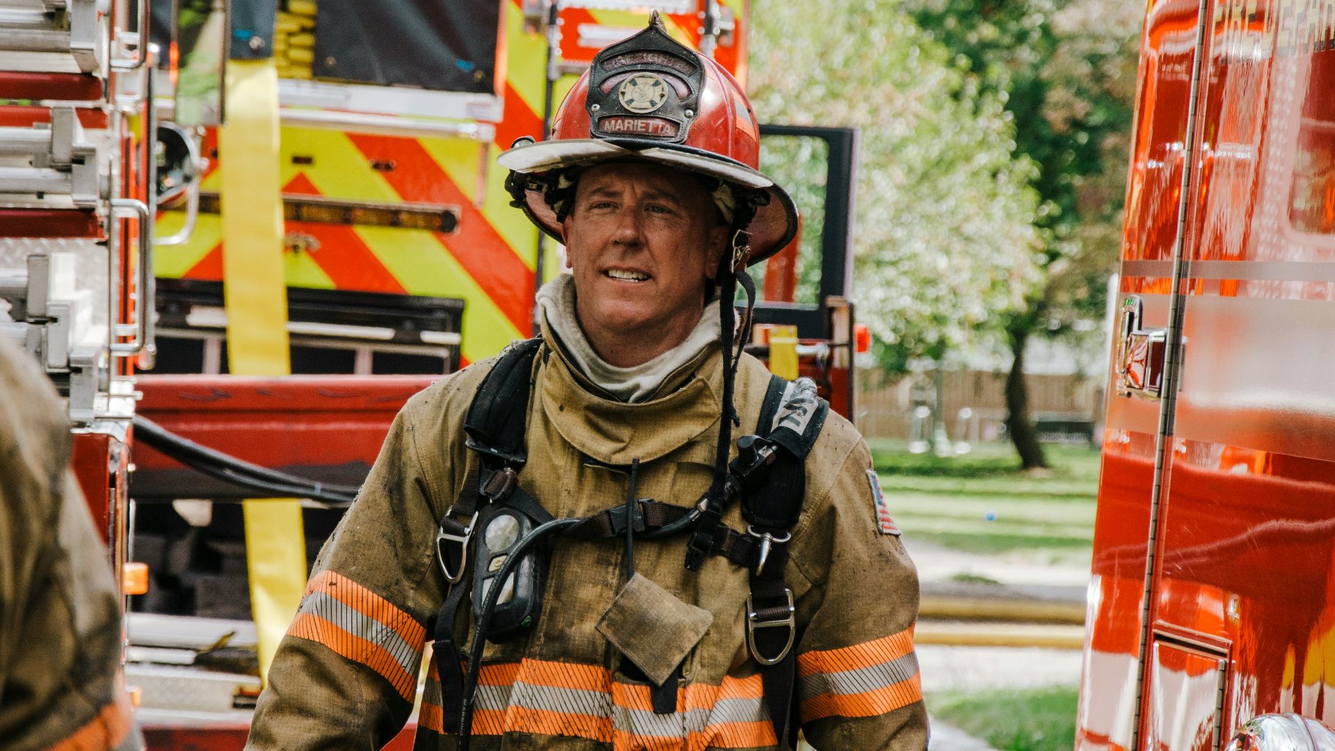 a fireman walking down a street next to a fire truck