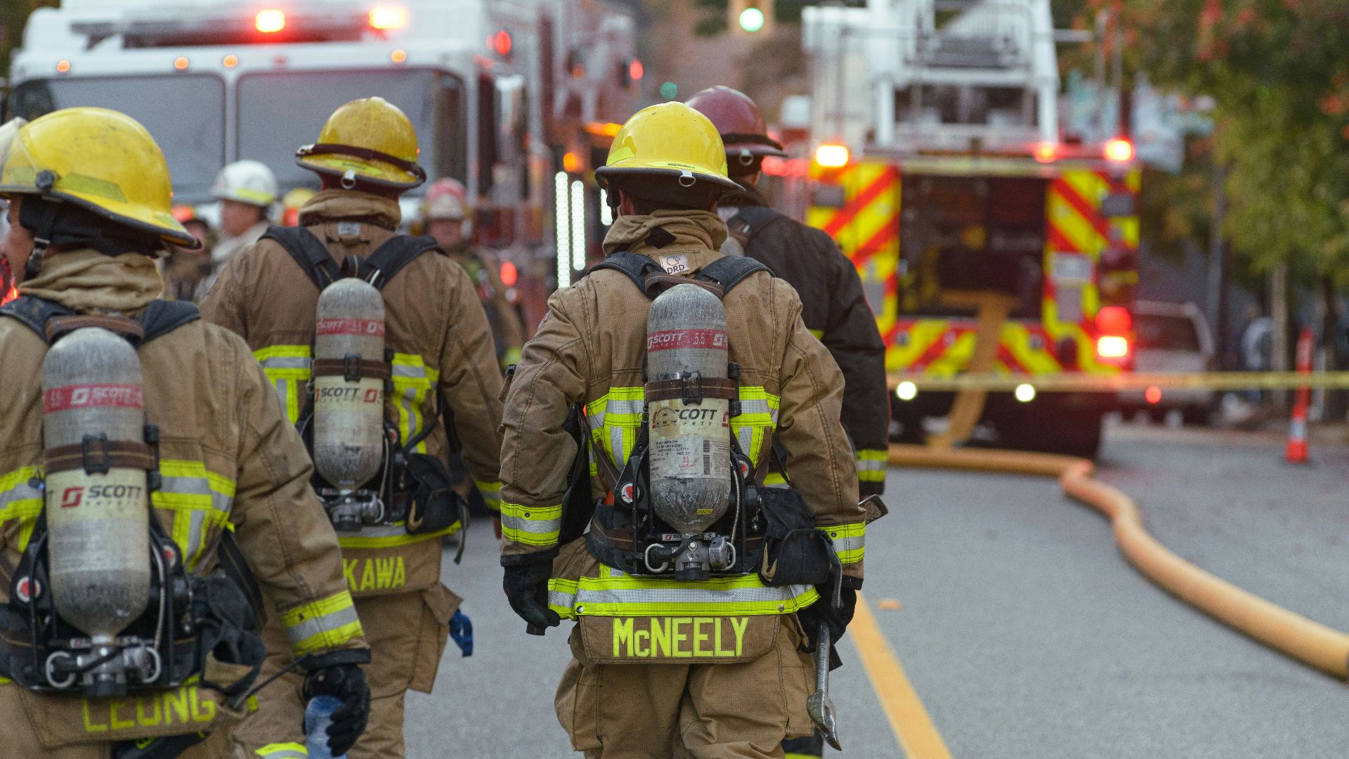 a group of firefighters walking down a street