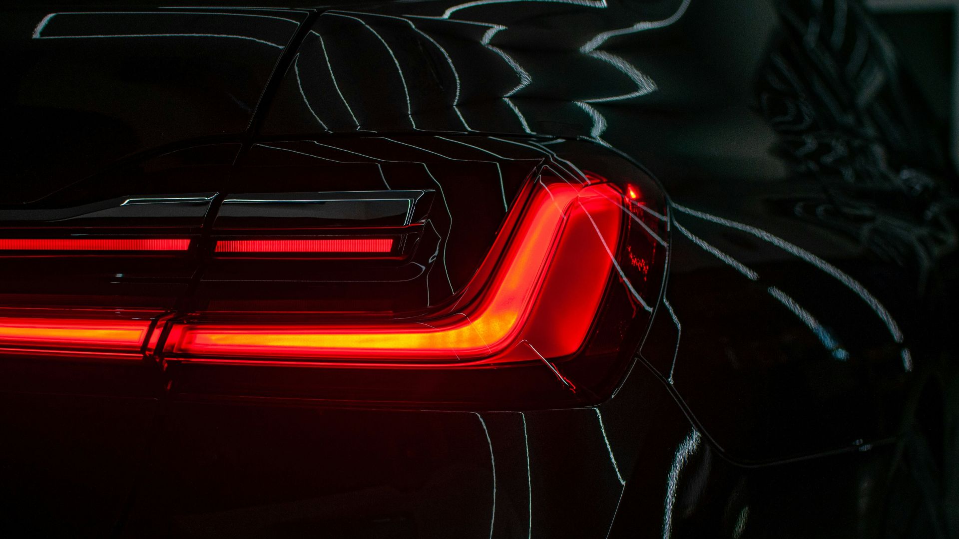 the tail lights of a black sports car