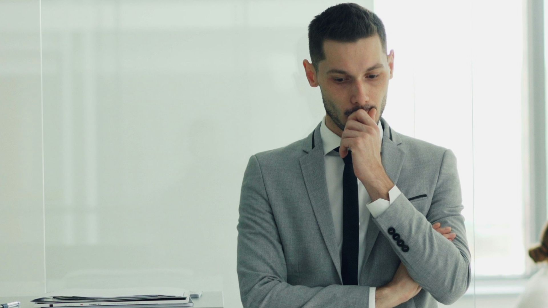 Man in suit thinking in modern office environment