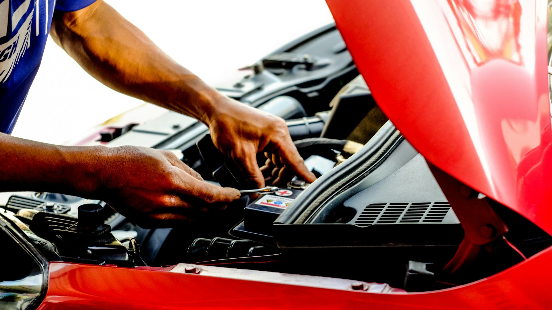 person fixing car during daytime