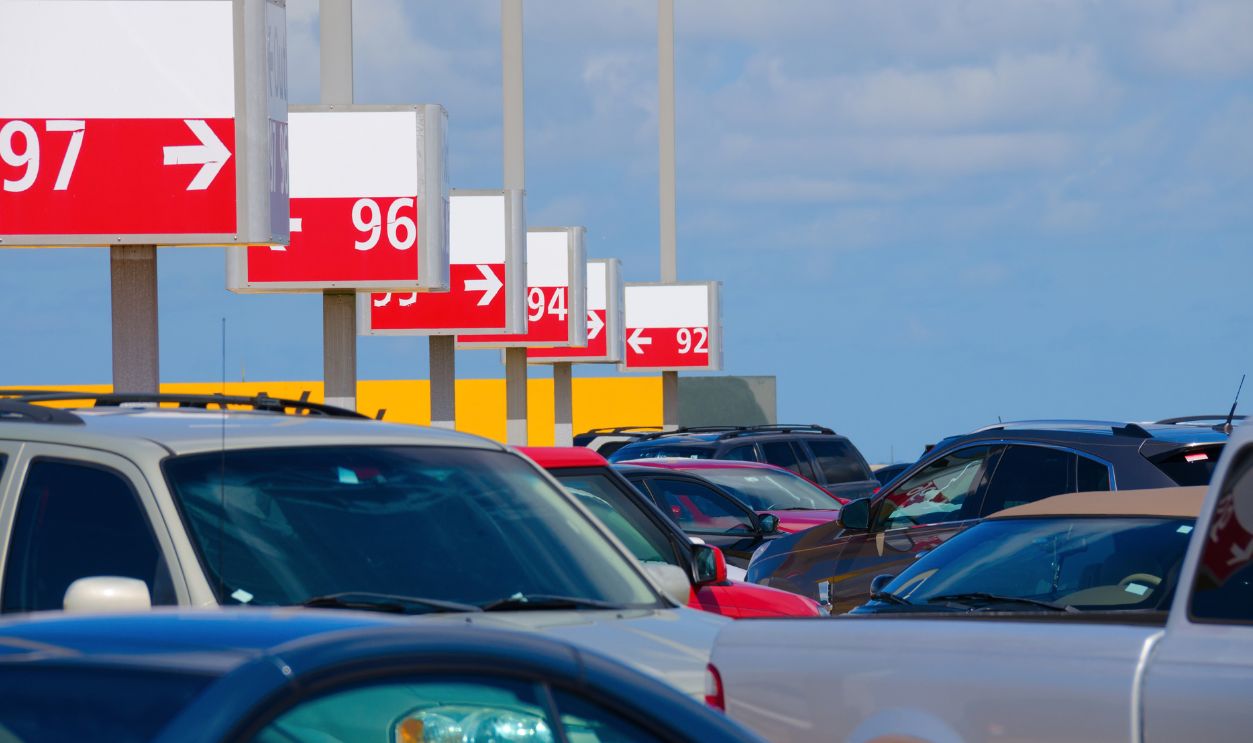 A numbered parking lot at an airport that is packed filled with automobile