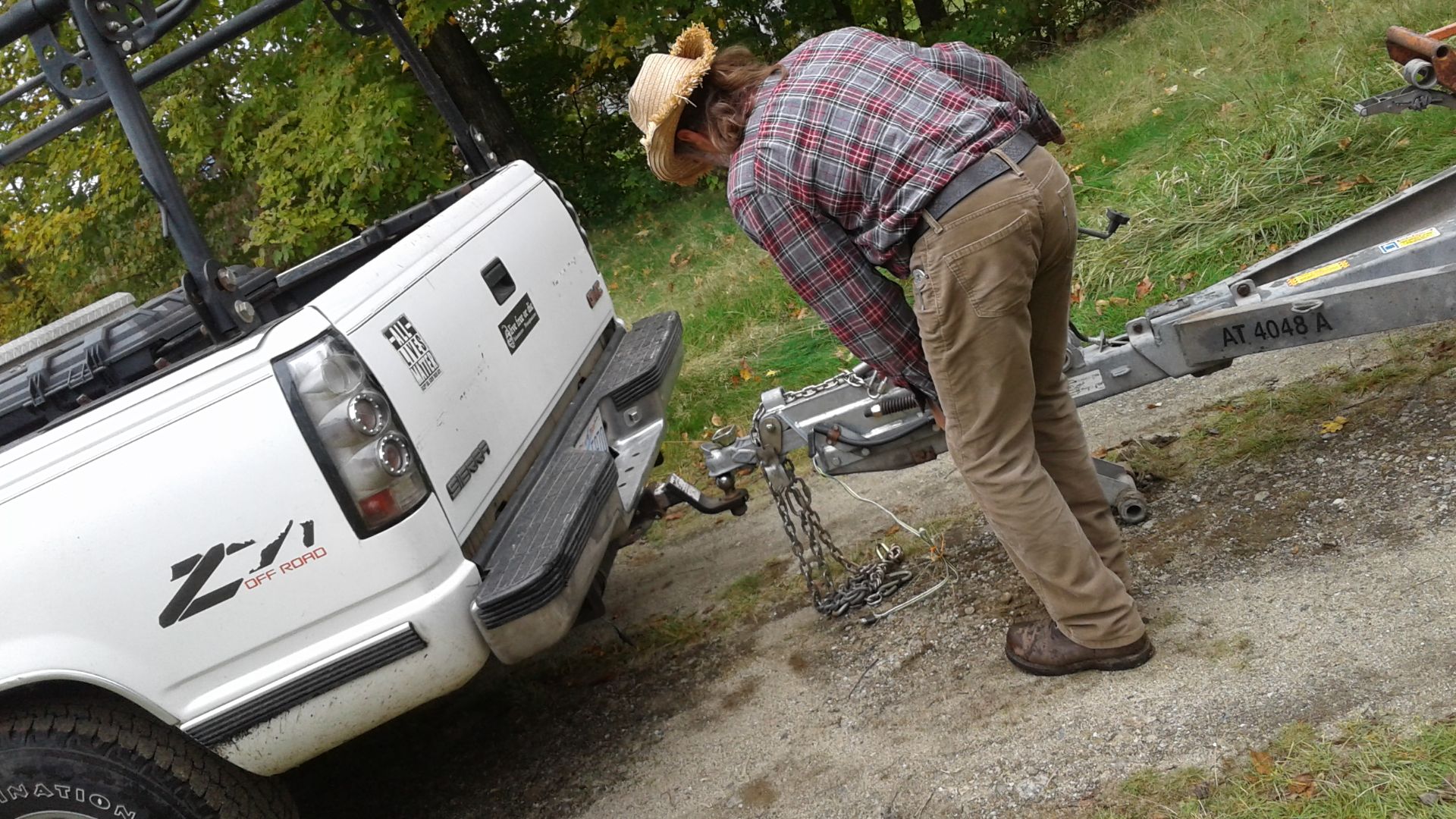 Hooking U-Haul auto transporter (trailer) hitch to GMC pickup truck in residential driveway in East Haven, Vermont.