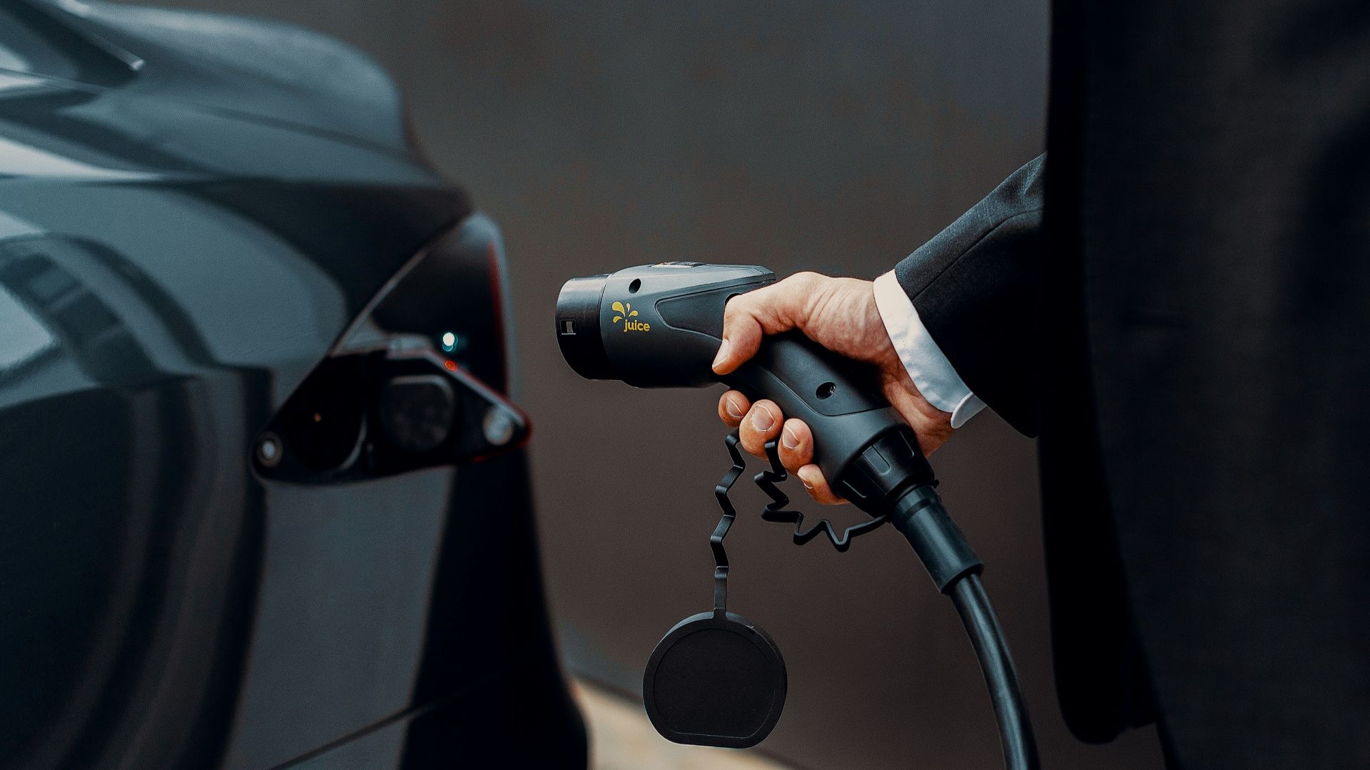 a man in a suit is pumping gas into a car