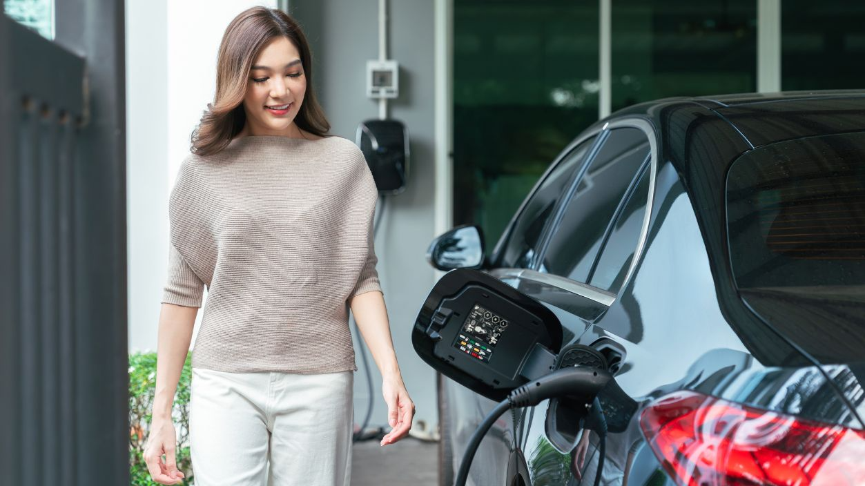 Shutterstock-2739488729, Female Driver Charging Electric Car at Home for Sustainable Transportation highlighting clean energy adoption and green lifestyle concept.