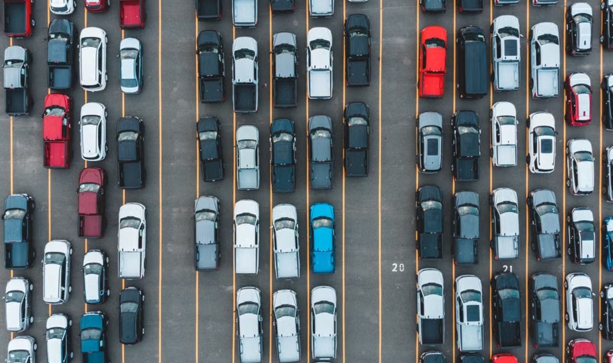 Aerial shot of parked cars in rows viewed from above, showcasing transportation and organization