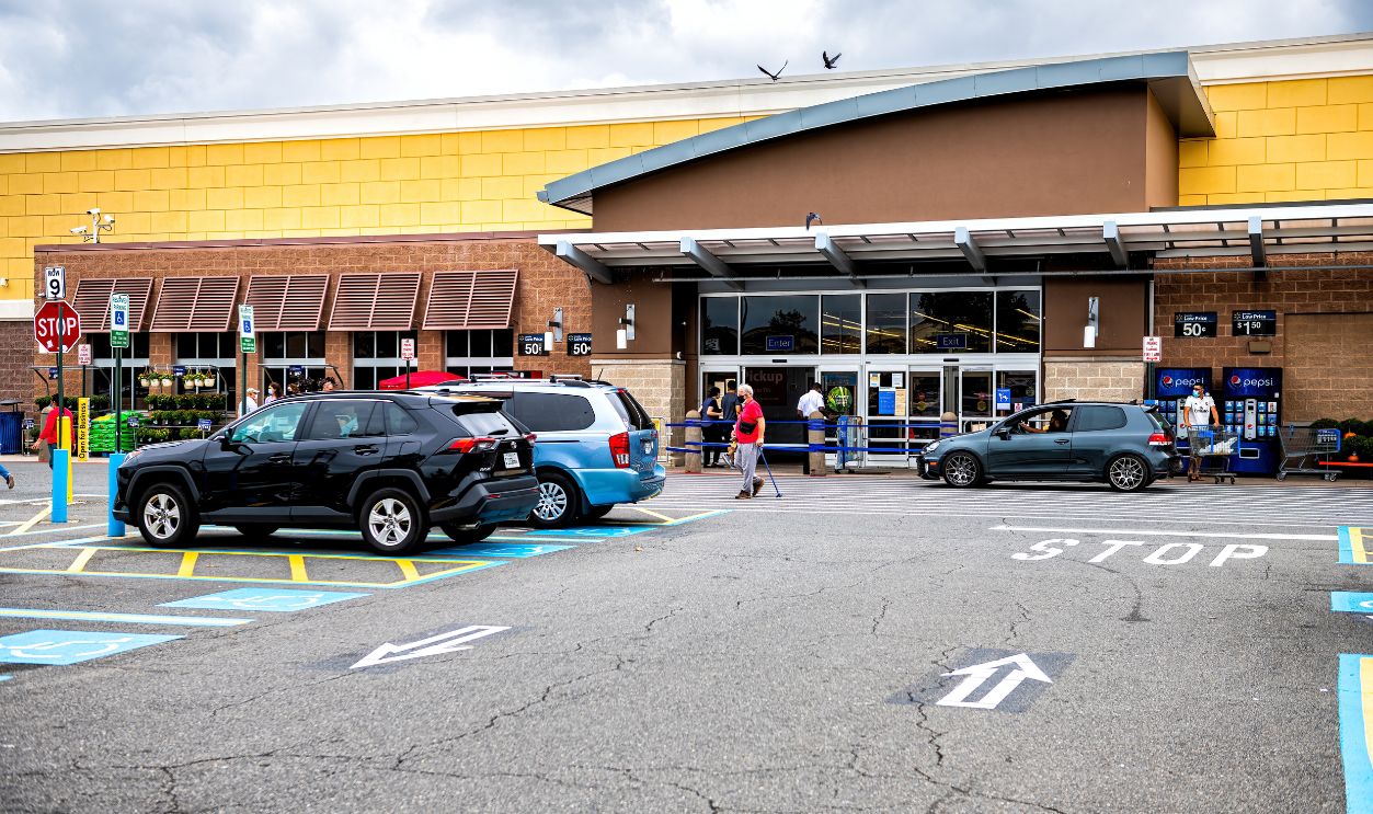 Sterling, USA - September 12, 2020: Walmart store entrance with shopping consumerism in Virginia and cars in parking lot