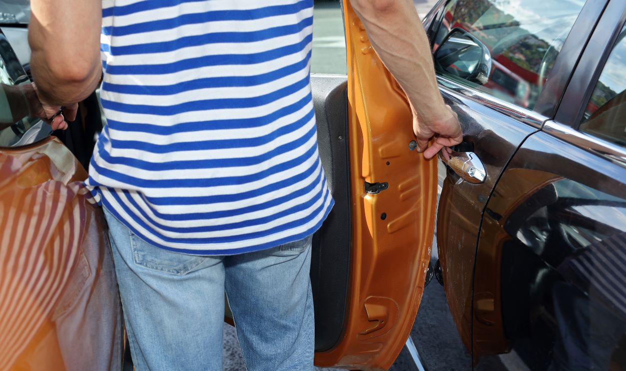 What should I do if I catch someone hitting my car with their door?