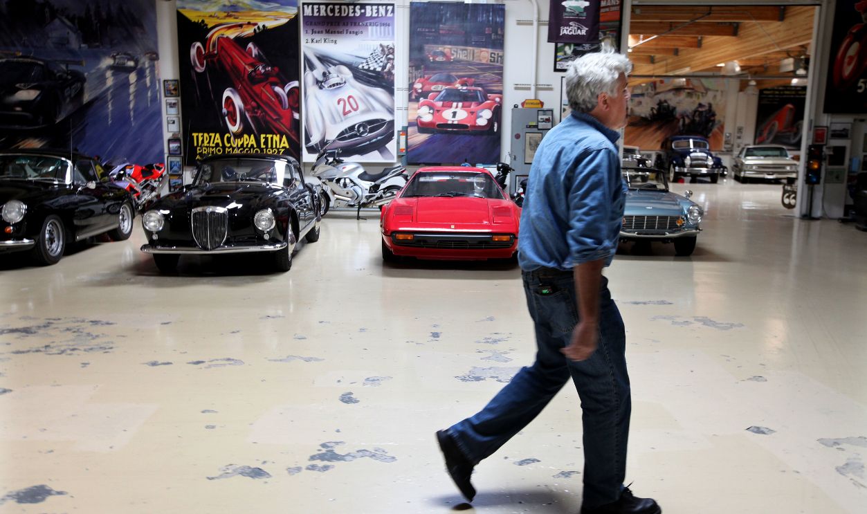 Getty Images - 526204724 - Comedian and talk show host Jay Leno walks by his Vintage car collection at Jay Leno's Garage in Burbank, California.