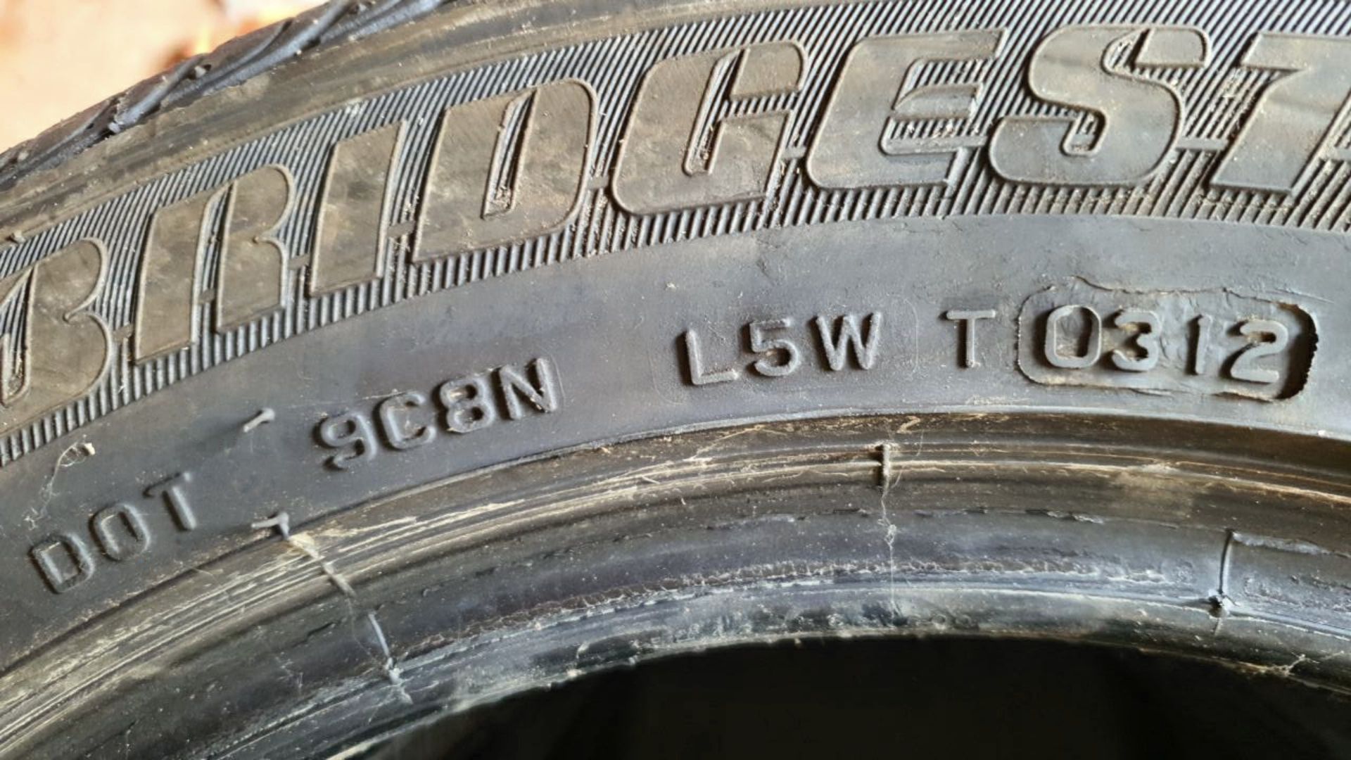 Die DoT Nummern auf einem BRIDGESTONE Autoreifen. Wobei die Abkürzung DoT für das amerikanischen Departmen of Transport, zu Deutsch das Verkehrsministerium steht. Die DoT-Nummer gibt Auskunft über das Fertigungsdatum des Reifens. In diesem Fall: 0312. Das
