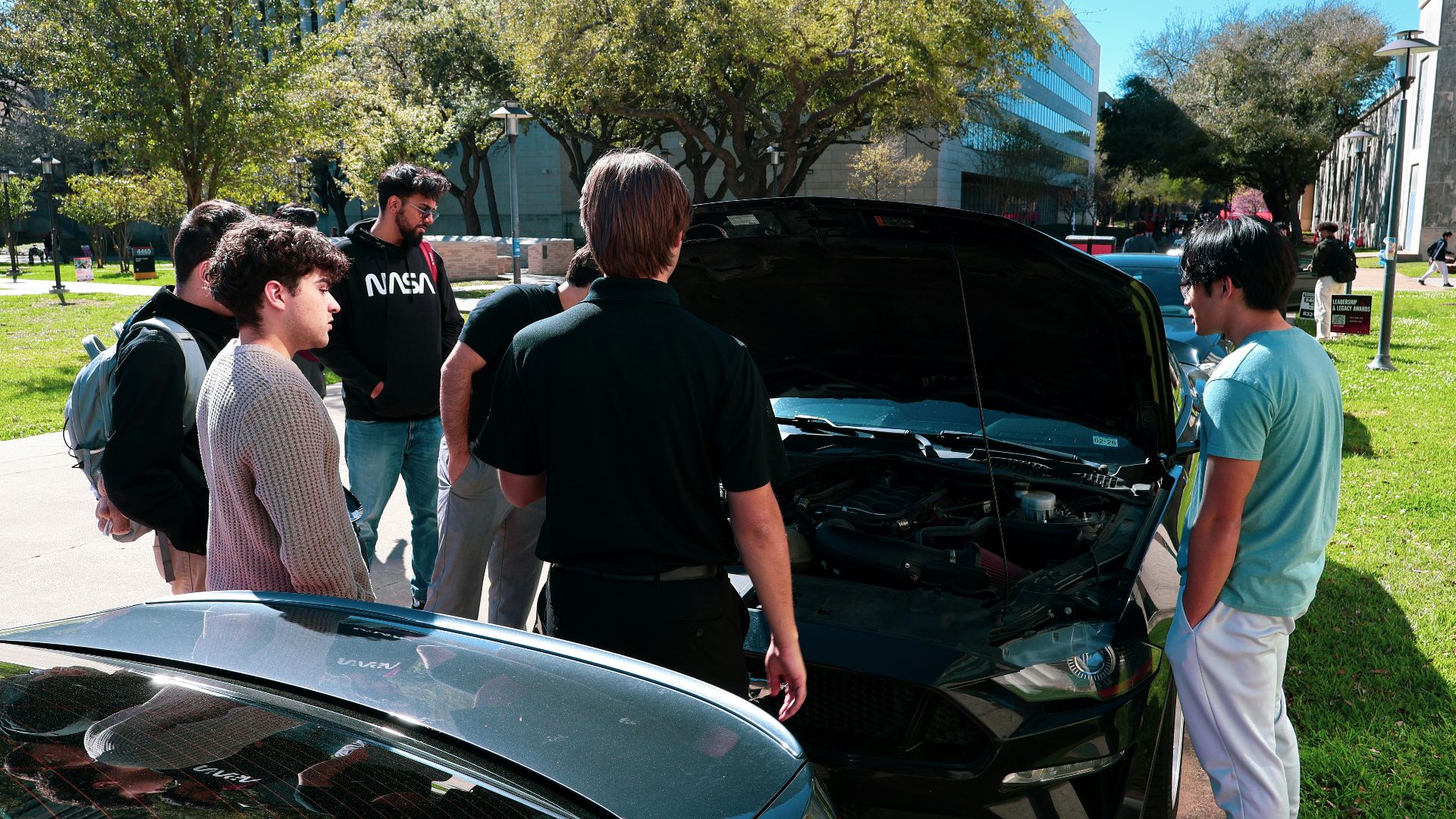 Group of people looking at car engine