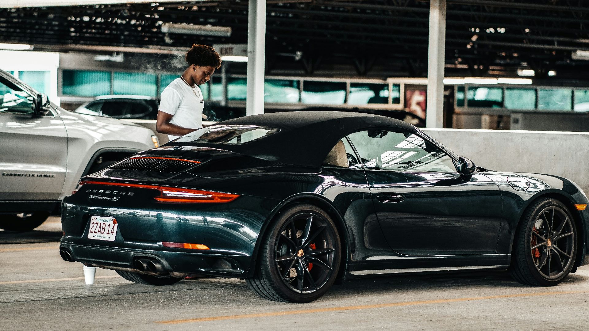 a person standing next to a black car