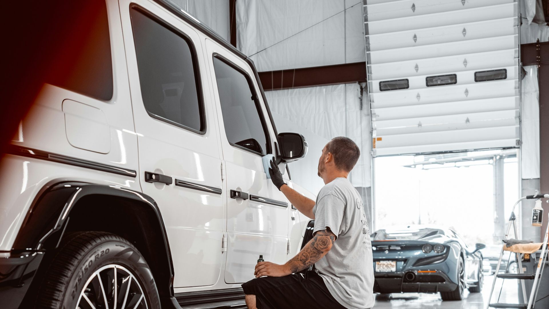 man in white dress shirt and black pants standing beside white suv