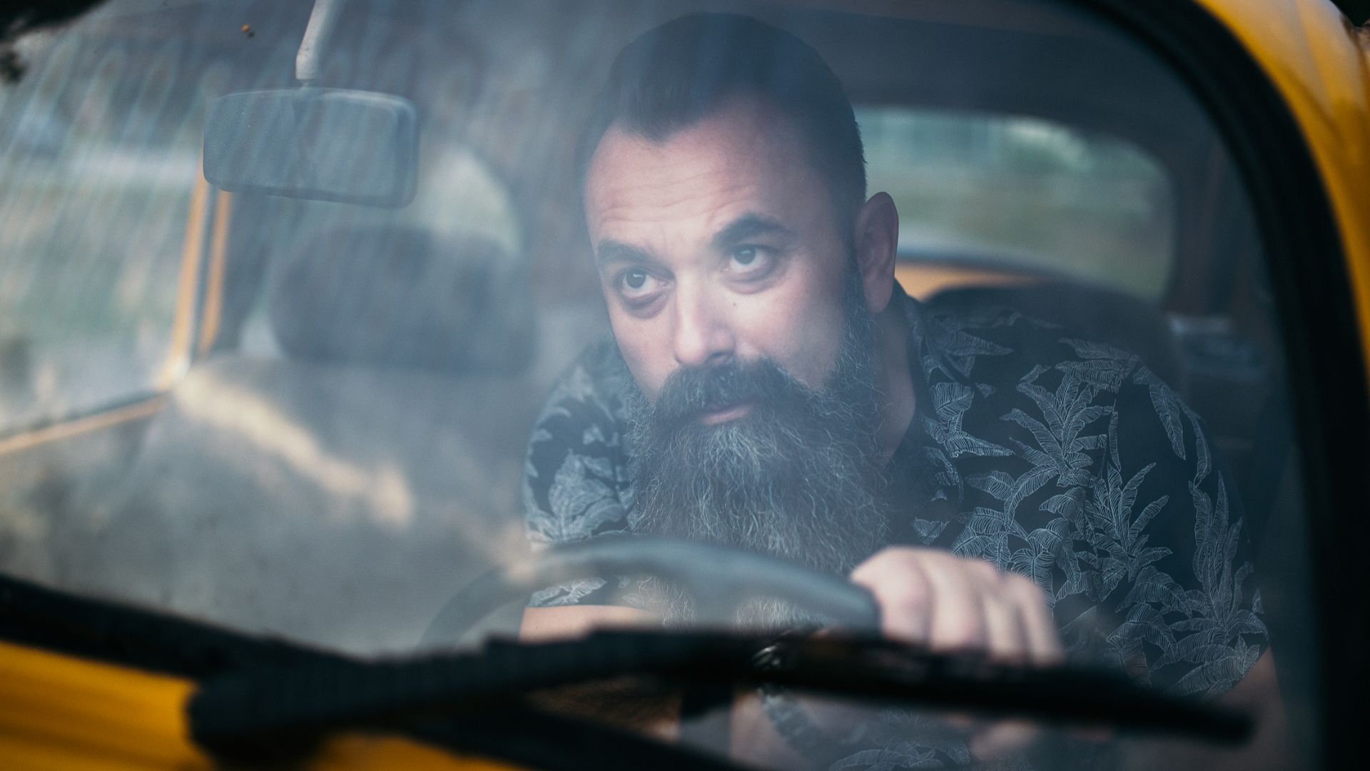 Bearded man in the car looking through the windshield