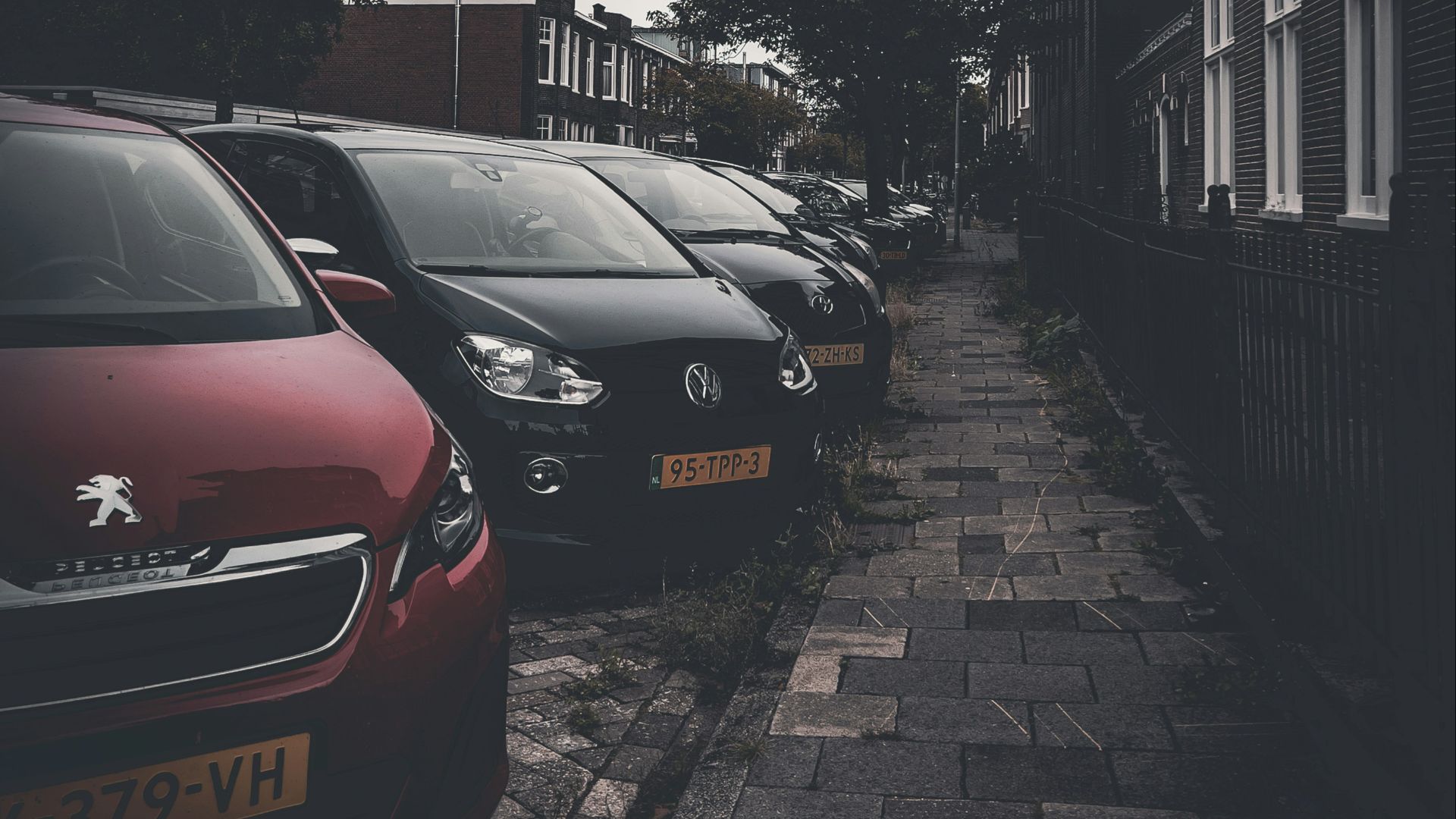 a row of cars parked on a brick road