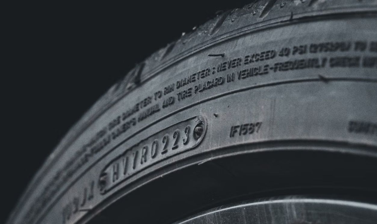 Detailed close-up image of a black car tire showcasing sidewall text and treads.