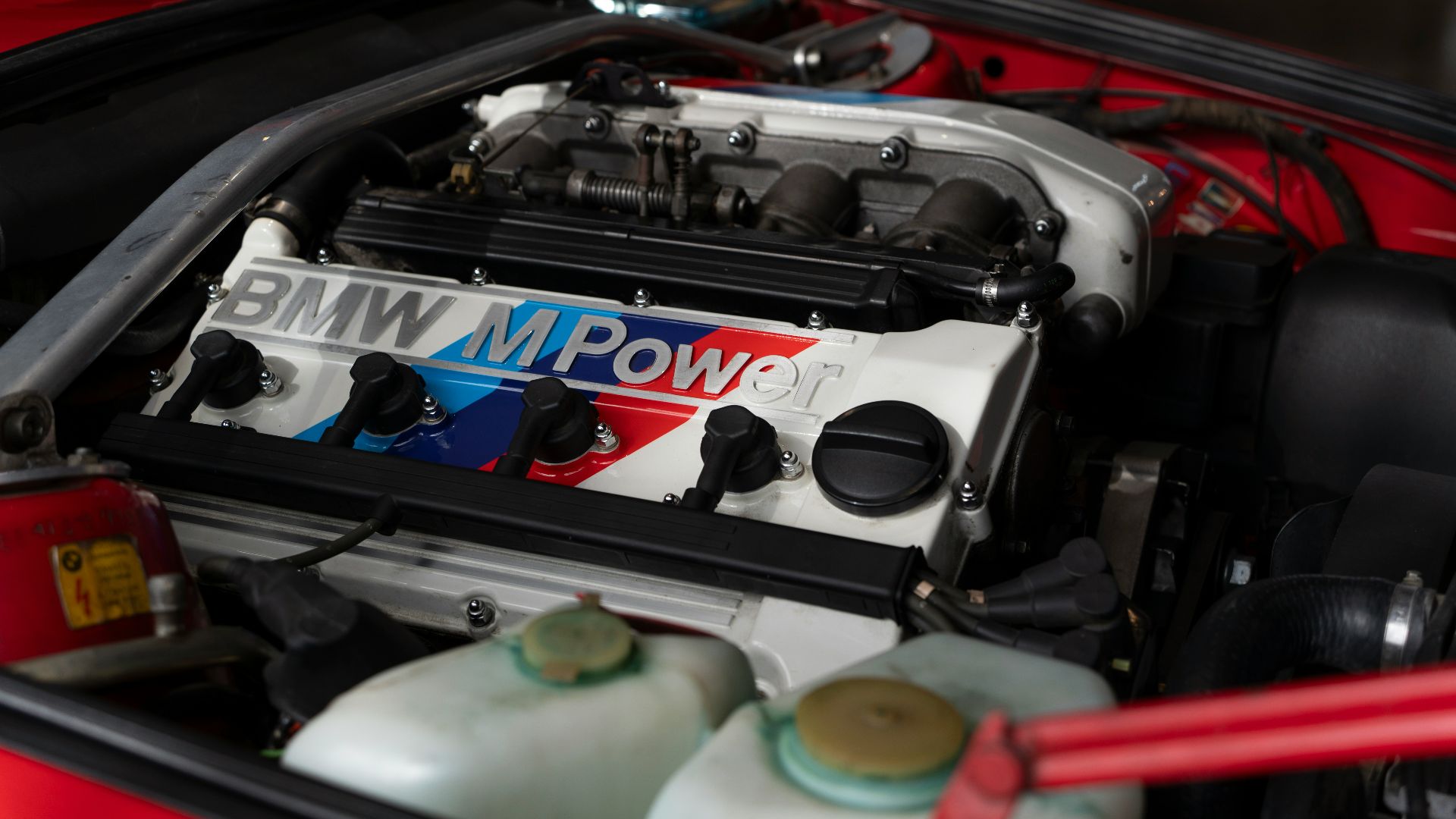 the engine compartment of a red sports car