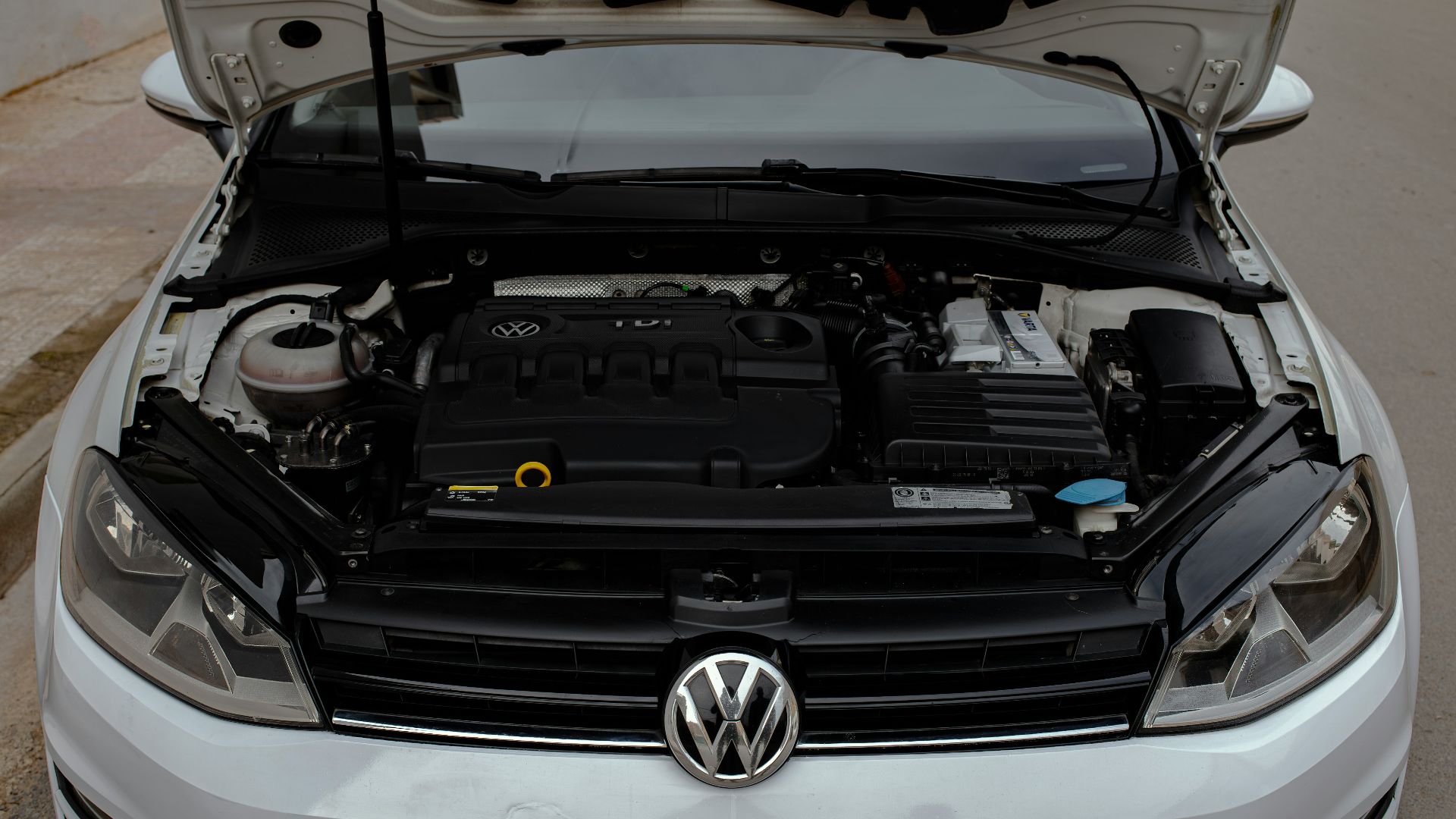 a white volkswagen car with its hood open