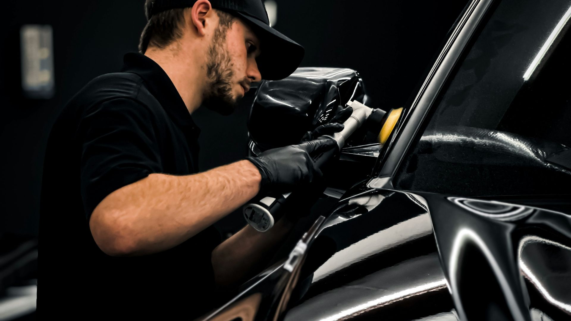 a man waxing a car in a garage