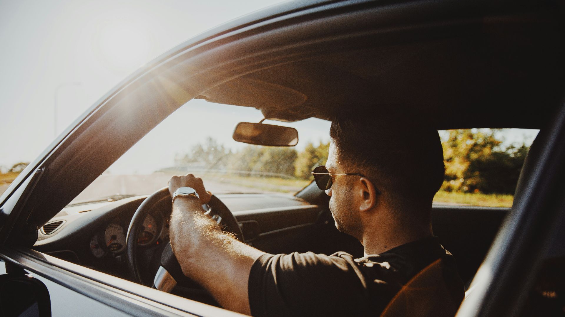 man in black jacket driving car during daytime