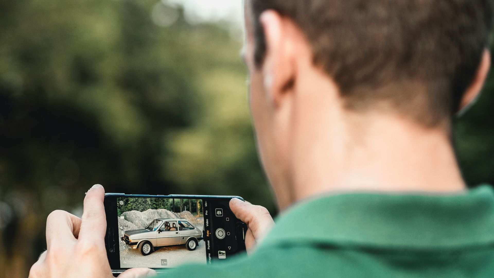 man taking photo of car