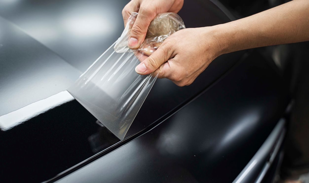 The worker is removing the paint protection car old film ; Car paint protection protect coating 