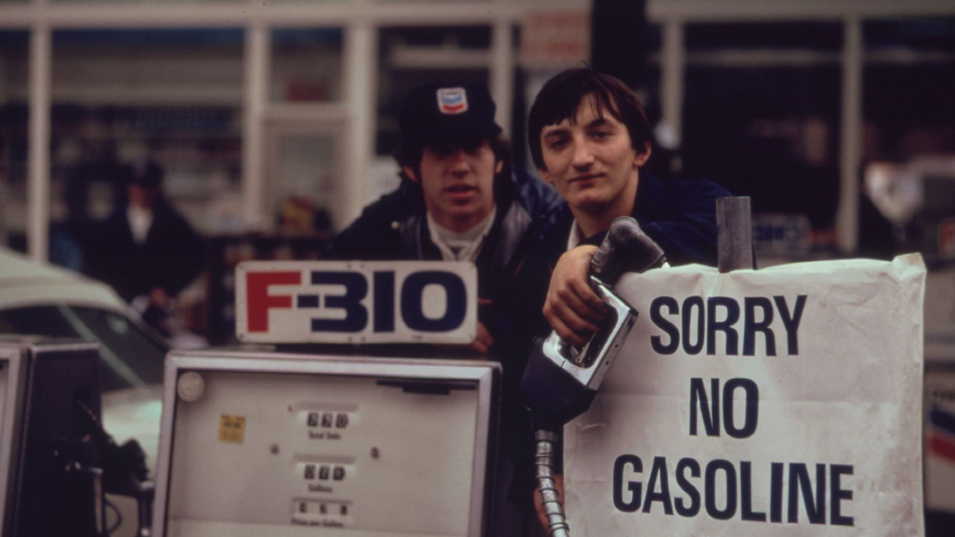 File:Gas station attendants peer over their