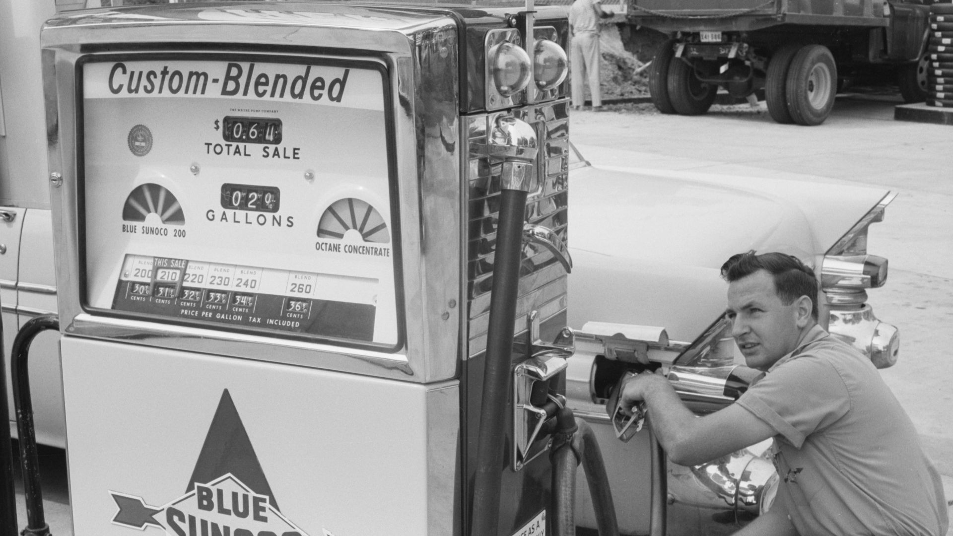 Gas station attendant filling a car tank with custom blend gas, at a Sunoco gas station, Washington, D.C. area