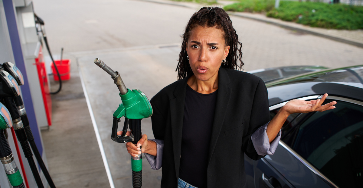 Frustrated driver reacting to expensive fuel bills while holding a dispenser handle at a petrol station