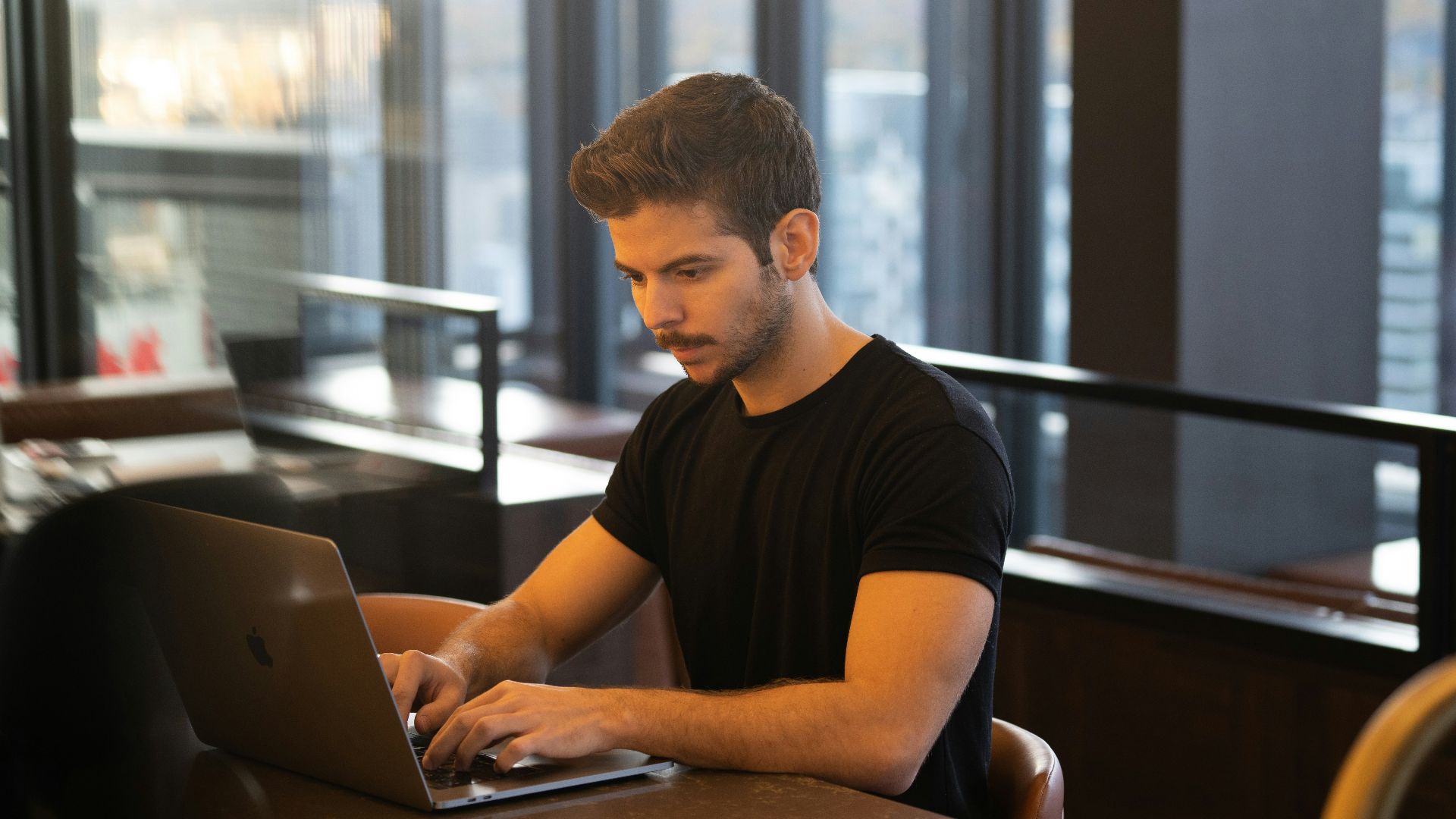man in black crew neck t-shirt using macbook