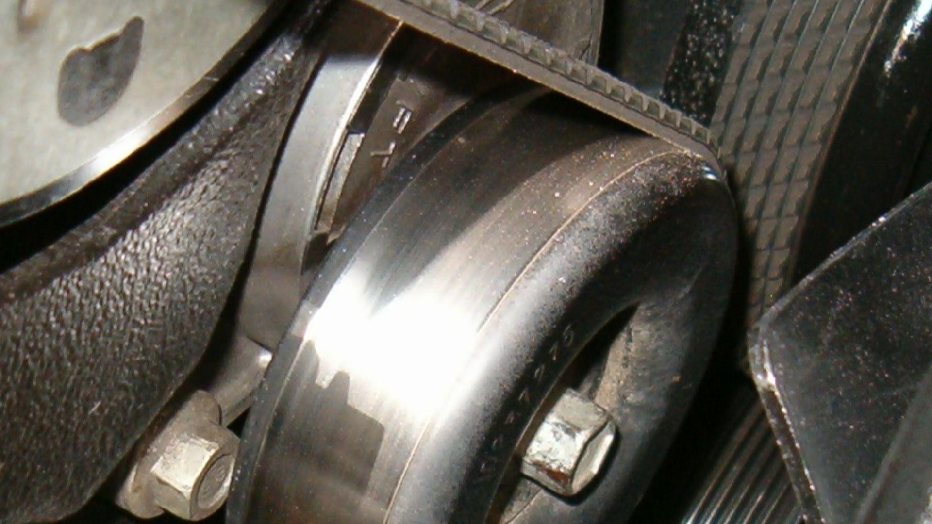 Tensioner in place on a model year 1999 7.4L automotive engine, tensioning the serpentine belt.